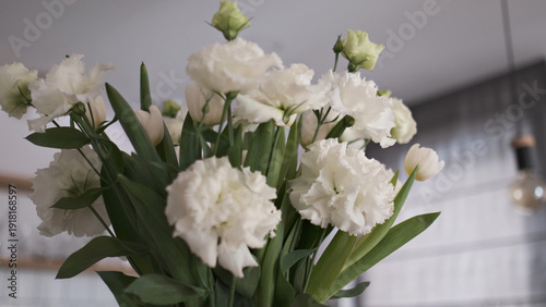 Obraz na plátně Elegant white carnations and lisianthus flowers in a lush bouquet with green fol