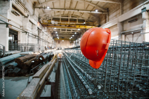 Tableau sur toile Orange hardhat on steel reinforcement cage in a large precast concrete factory w