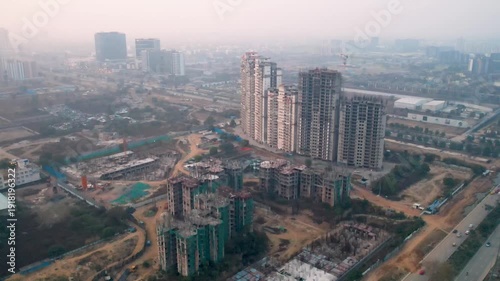 Drone view of residential towers and active construction site in Gurgaon Delhi NCR, highlighting urban expansion, real estate growth, and infrastructure development.