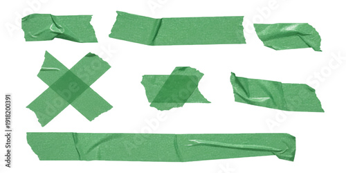 A collection of various pieces of green adhesive tape, including strips and an x shape, isolated against a white background
