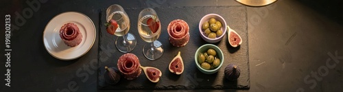 Obraz  z motywem Charcuterie slate board with salami roses figs olives and sparkling wine for party appetizer menu and entertaining background