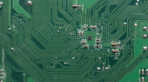 Close-up view of a green circuit board with electronic components and intricate pathways