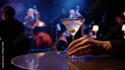 Hand Reaching for a Classic Martini Cocktail at an Elegant Live Jazz Music Performance in a Stylish Bar.