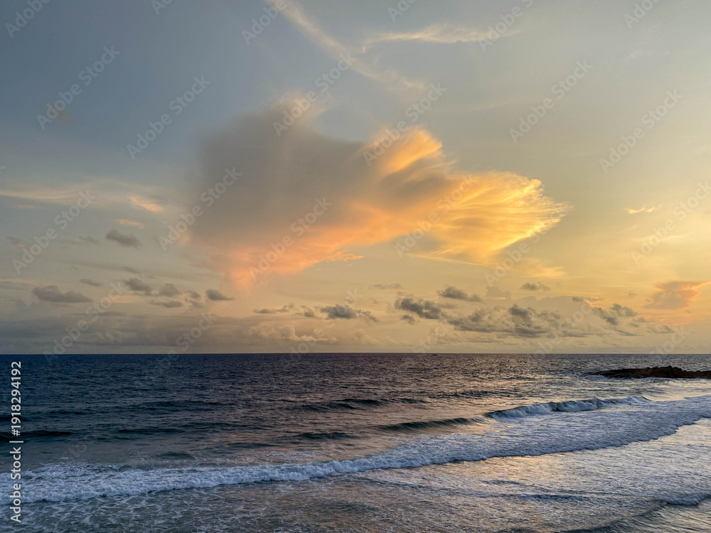 Obraz premium Dramatic Sunset Over Open Ocean, Fiery Cloud Formation Glowing Above Steady Waves, Wide Horizon Line, Warm Orange And Pink Tones, Tranquil Water
