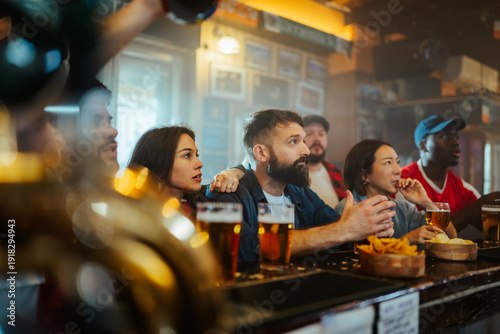 Wallpaper Mural Diverse friends watching sports game in pub Torontodigital.ca
