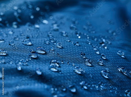 Water drops on waterproof membrane fabric. Detail view of texture of blue waterproof cloth.