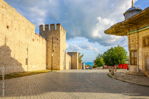 Canvas Print The historic stone walls of the Topkapi Palace near the Imperial Gate entrance, with the Fountain of Sultan Ahmed III in front, in Sultanahmet District of Istanbul