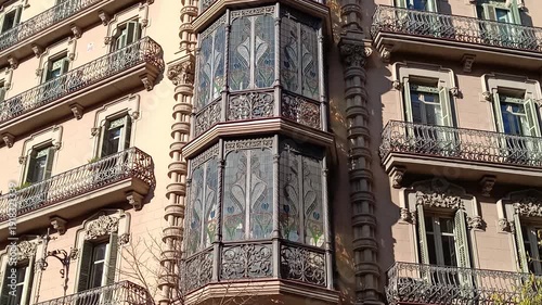 Camera tilting up a beautiful modernizm style building with intricate balconies and stained glass