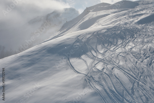 Fresh ski tracks on snowy alpine slope in Stoos