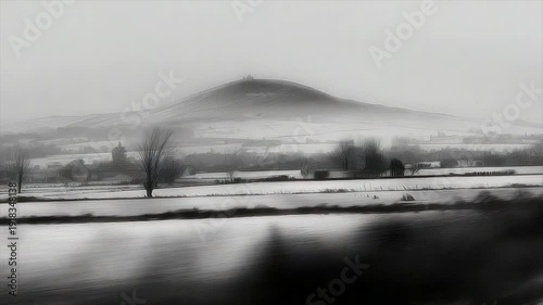Wallpaper Mural A monochrome landscape depicts a snow-covered field with a prominent hill in the background Torontodigital.ca