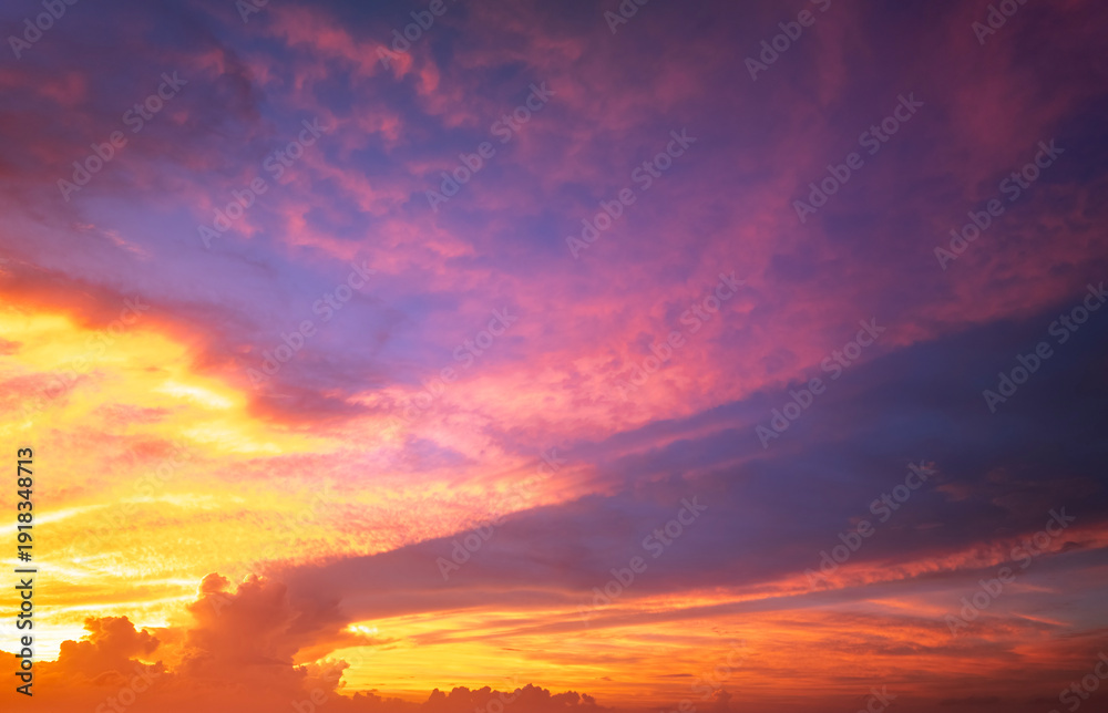 Fototapeta premium Bright sunset with setting sun behind vivid orange and yellow clouds