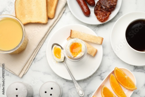 Tasty breakfast with soft boiled egg and toasted bread served on white marble table, flat lay