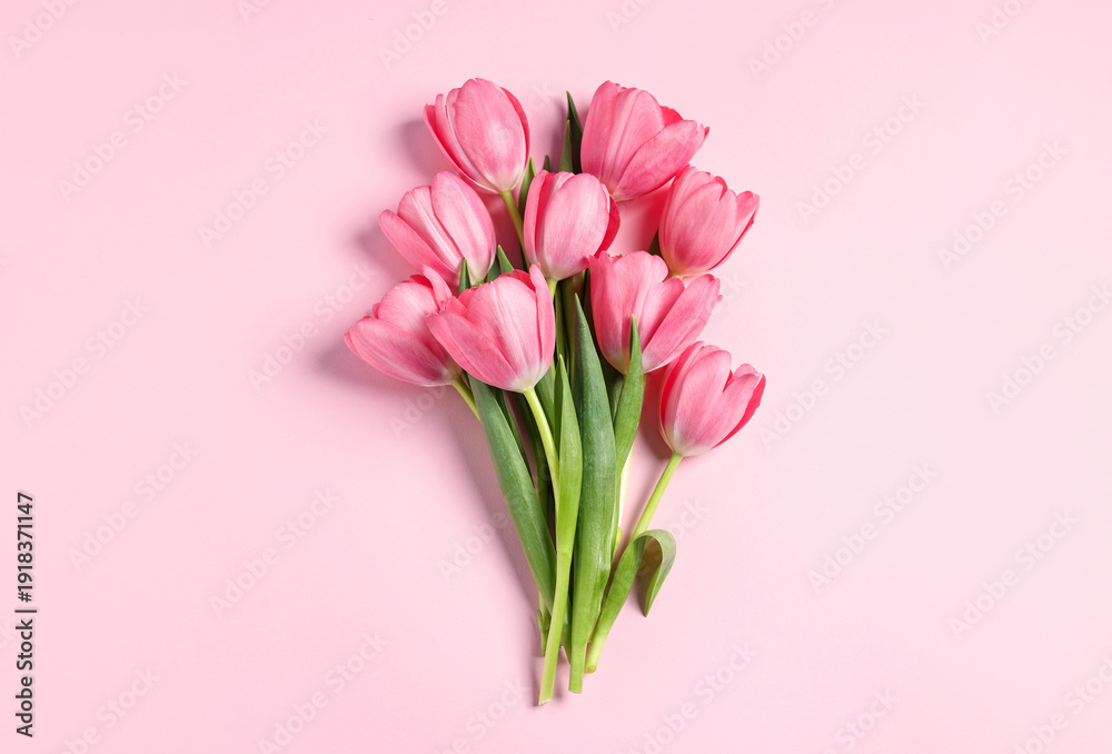 Fototapeta premium Bouquet of tulips on pink background, top view