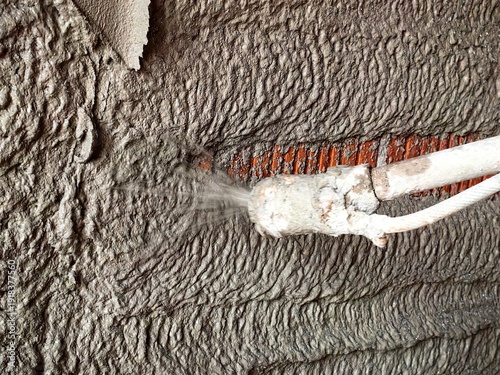 Construction worker applying cement plaster coating to a wall using a machine. Machine Plastering, process involves a plastering machine that sprays mortar onto surfaces to achieve a smooth and consis