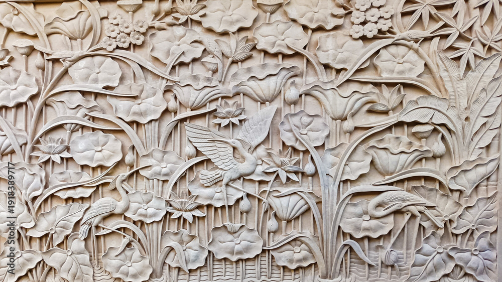 Obraz premium Detailed Indonesian limestone carving of a lotus pond with a stork and flowers. Background texture.