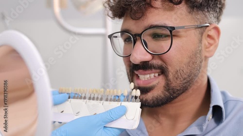 Dentist matching patient's tooth color for whitening