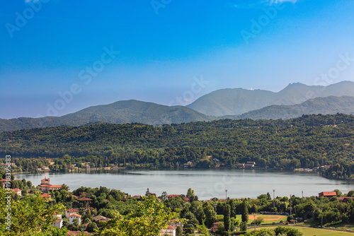 Foto Aerial view of Avigliana lake, Italy, Piedmont, Turin, Italy A beautiful town with and red-roofed houses, surrounded by the green hills of Susa and trees