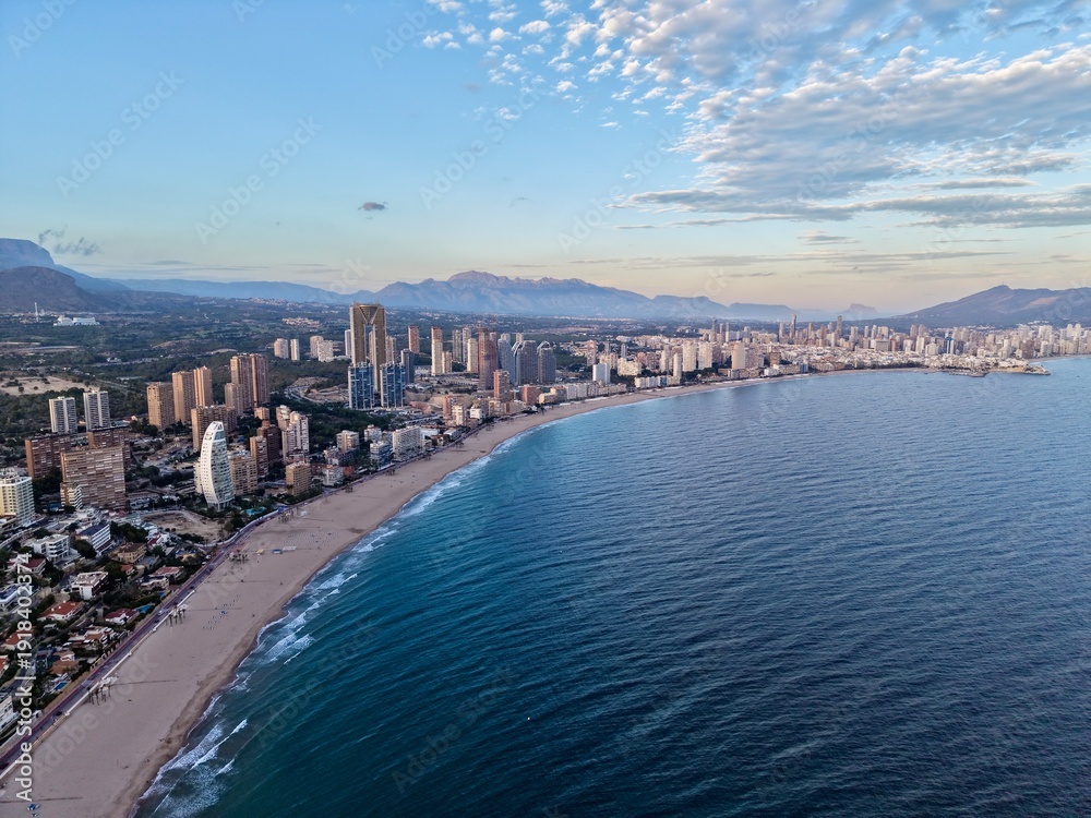 Obraz premium picturesque shoreline featuring highrise structures and generous stretch of golden sands under serene sky