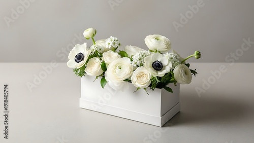 A bouquet of white flowers in a white vase on a table with a plain background