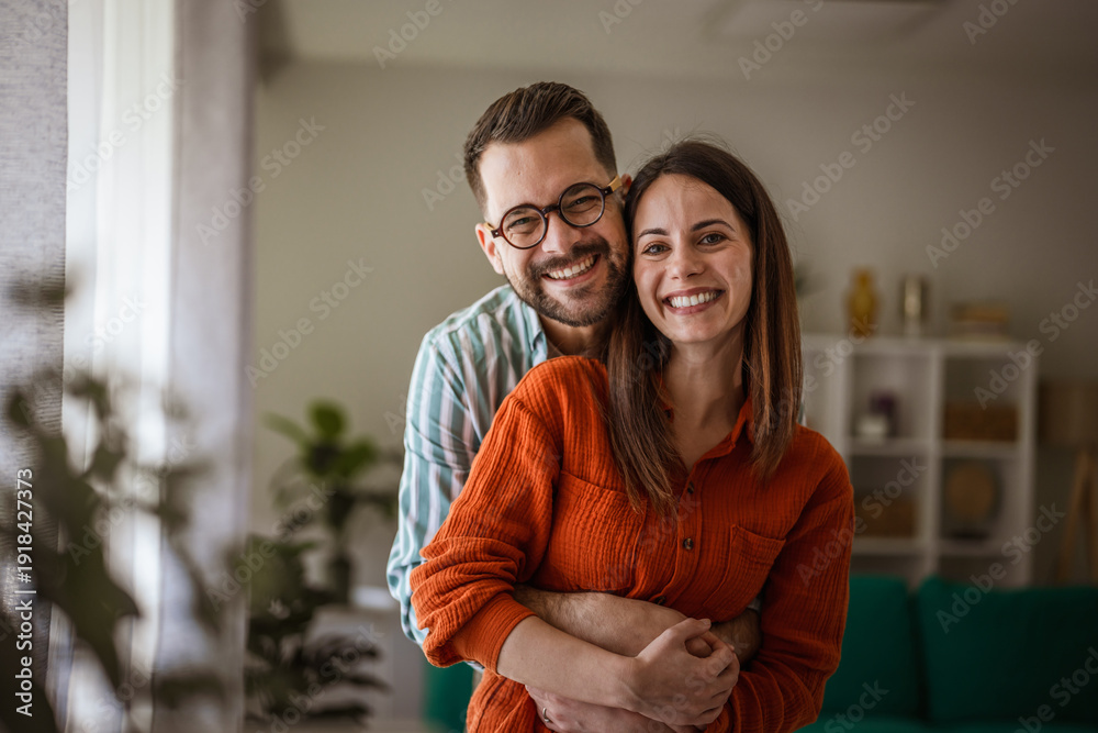 Fototapeta premium Happy couple embracing at home showing togetherness