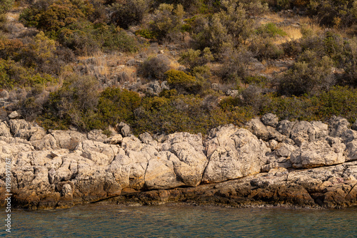 The coastline of Thassos Island. The marine landscape in Greece. Rocks, sea, trees, sky.