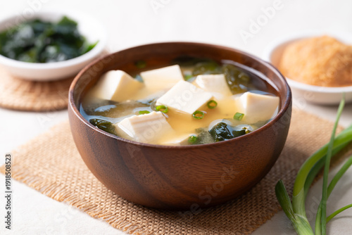 Healthy Japanese miso soup with soft tofu and seaweed in a wooden bowl