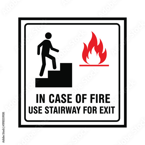 A black and white sign with a red fire icon and a person walking up stairs, instructing to use stairway for exit in case of fire.
