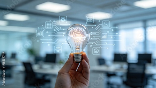 Hand holding light bulb with glowing brain and digital interface icons,creative innovation and artificial intelligence concept in modern office environment
