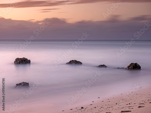 Dreamy ambient shot of rocks sticking out of the sea