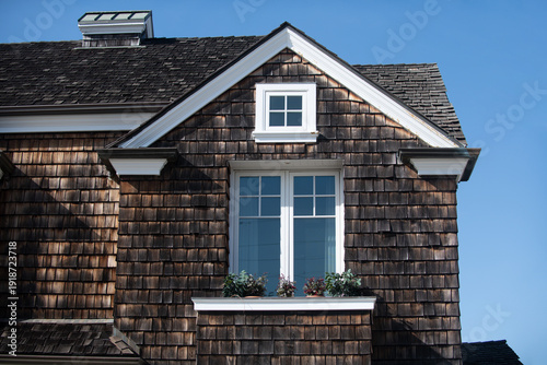 House with cedar shingles feels inviting. Your classic house facade with a bright window looks clean. Their traditional house with a flowerbox adds charm.