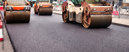 Fotografija Construction workers are laying asphalt concrete on a bustling city street
