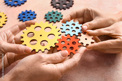 Hands holding wooden gears ...
