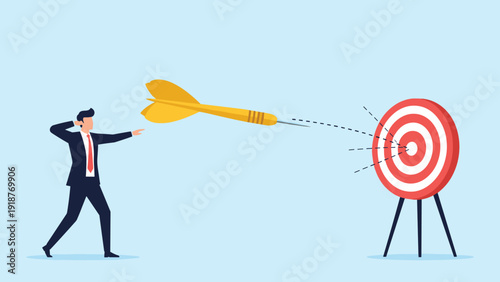 Focused businessman throwing a large golden dart at a target to reach his goals and achieve business success.