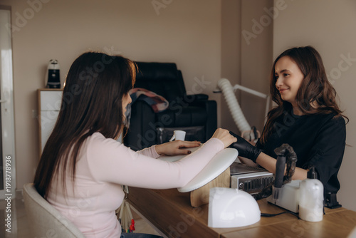 Nail technician applying manicure during beauty treatment