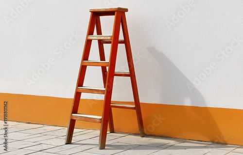 Shadow climbing upward of a red ladder against a wall