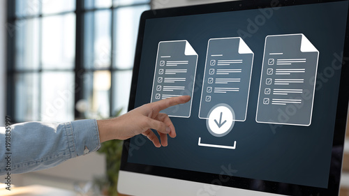 Digital Download at Your Fingertips: A close-up view of a hand interacting with a computer screen, highlighting the ease and accessibility of online file downloads.