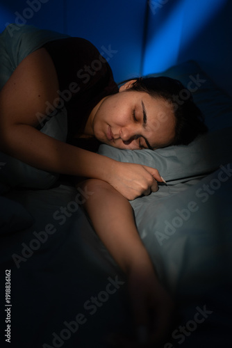 Portrait of young woman sleeping sweetly at night in moonlight peacefully resting in bed