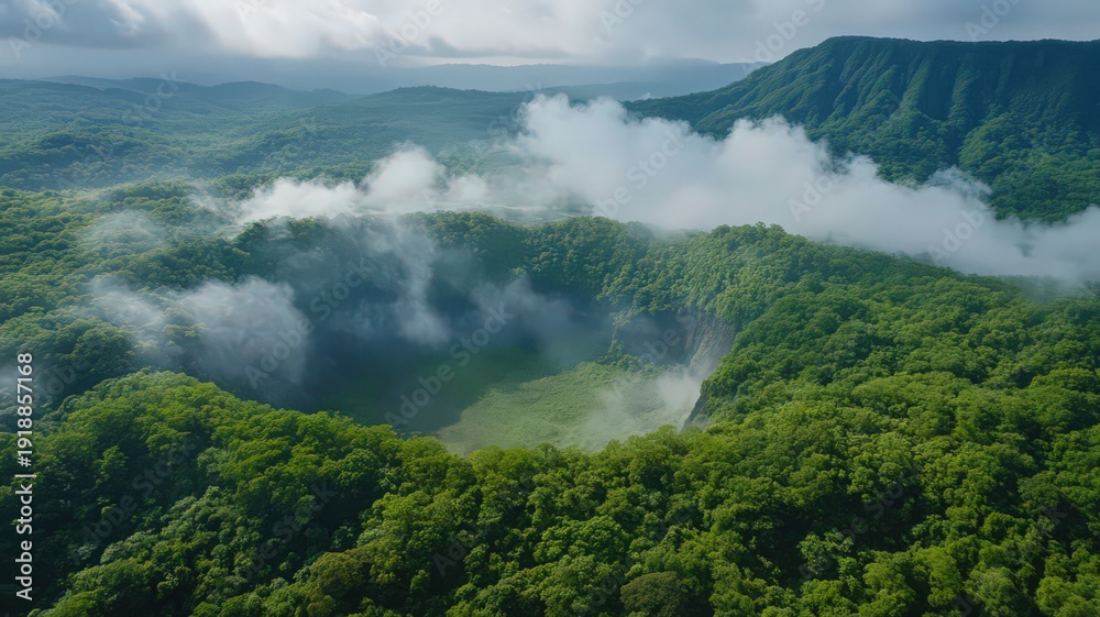 Obraz premium Aerial View of a Volcanic Crater Surrounded by Lush Greenery and Misty Clouds in Nature
