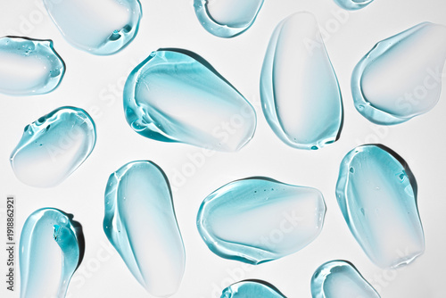 Pure blue transparent cosmetic gel smears on white background, skin care glycerin texture. top view