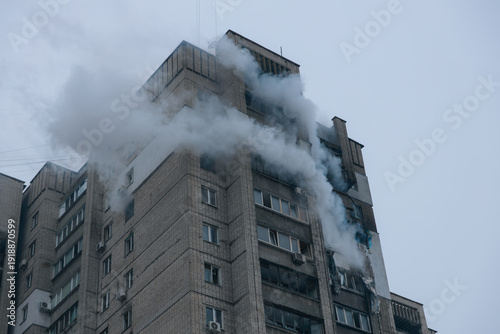 Fotografia Dense smoke pours from a severely damaged high-rise apartment building