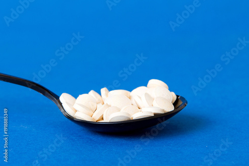 Wallpaper Mural Heap of white pills on colored background. Tablets scattered on a table. Pile of red soft gelatin capsule. Vitamins and dietary supplements concept Torontodigital.ca