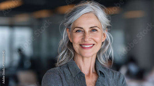 A middle-aged woman with gray hair smiling in a professional office setting