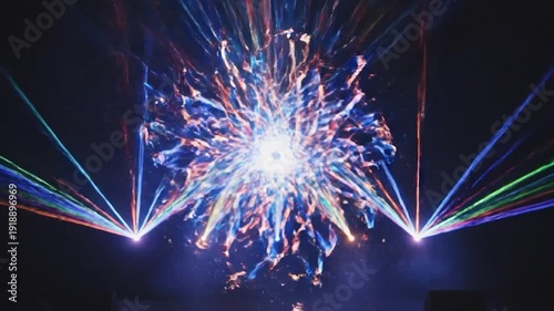 Vibrant colorful laser light beams illuminate a dark stage background
