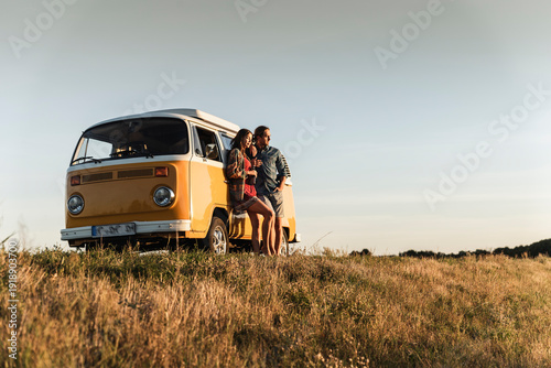 Wallpaper Mural Young couple leaning on their camper watching the sunset Torontodigital.ca