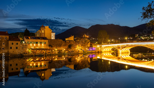 Night cityscape. Trebinje is a city in Bosnia and Herzegovina; the historical center of the city. Buildings are reflected in the river