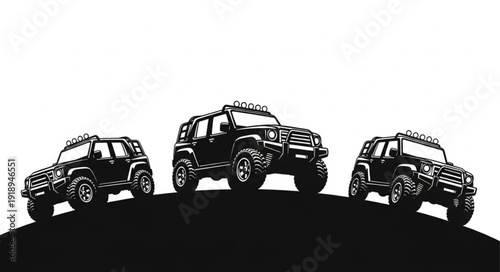 Three black off road vehicles on a hill.