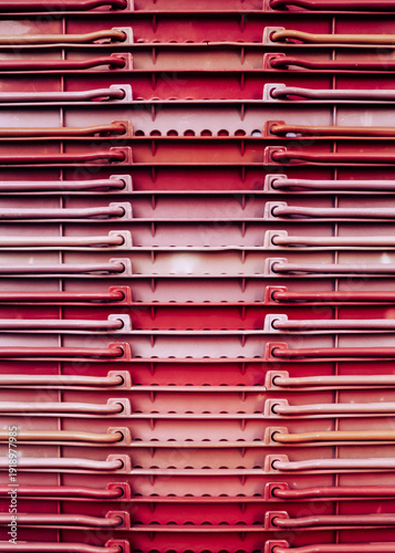 Red abstract geometric background texture from stacked plastic shopping baskets
