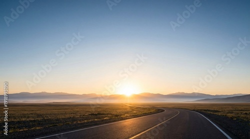 Schilderij op canvas A winding asphalt road leads across a vast open landscape towards a bright sunri