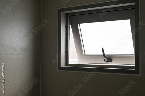 Fotografía Open bathroom window modern gray tile wall natural light ventilation minimalist