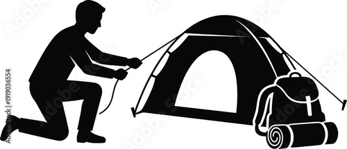 Silhouette Person setting up a camping tent outdoors with backpack nearby